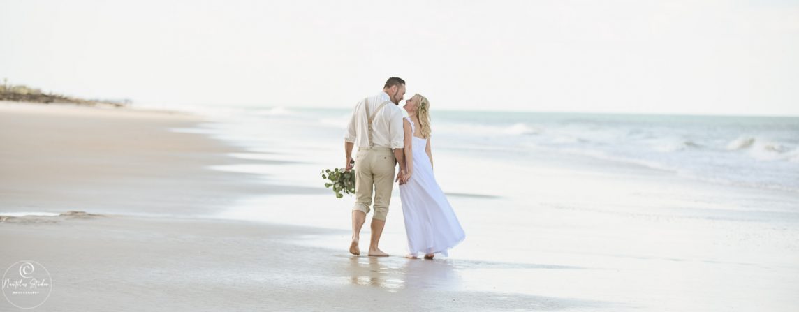 Photo of elopement wedding couple walking down the beach