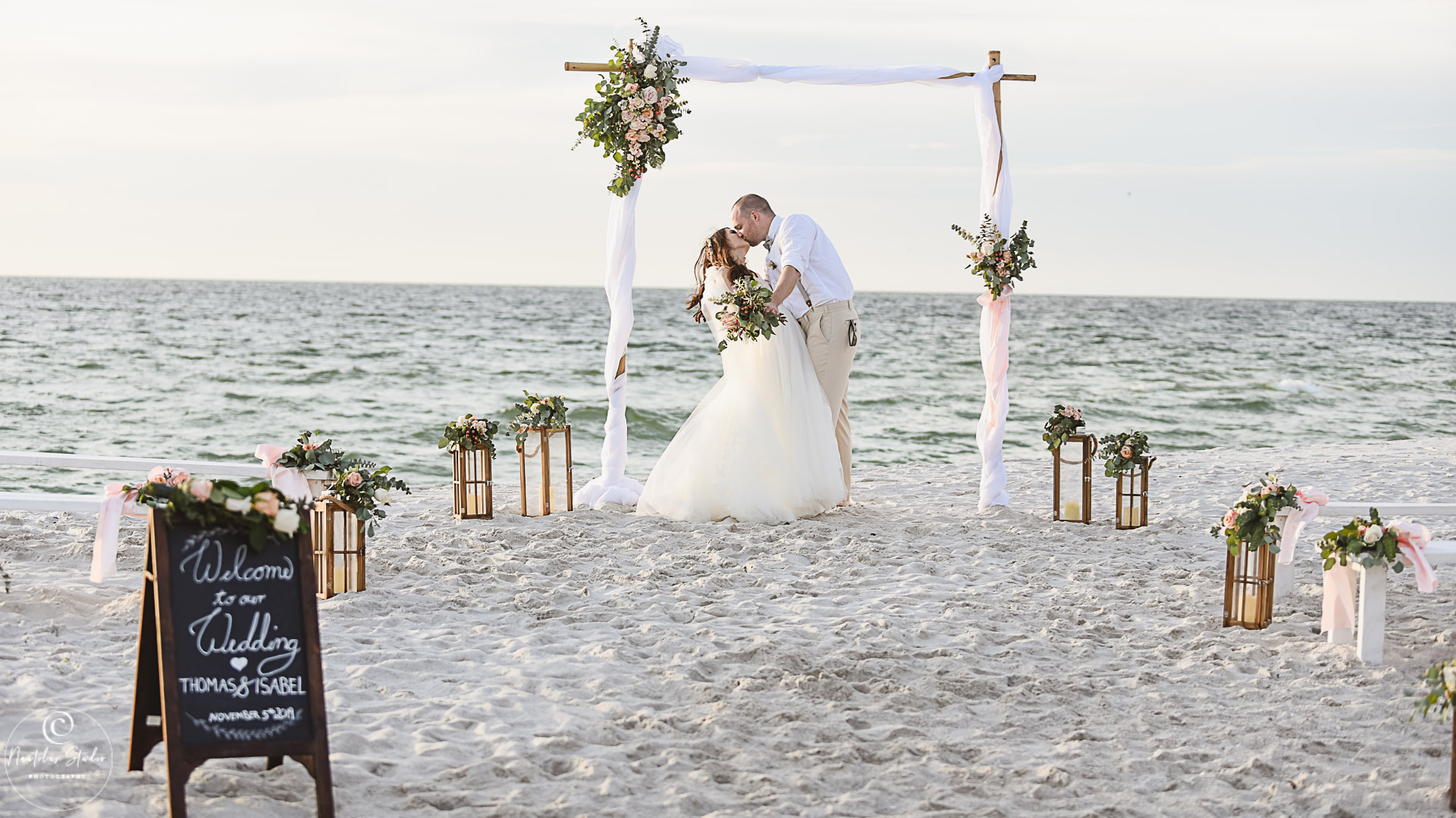 Photo of elopement beach wedding in Naples Florida showing couple kissing under the archway