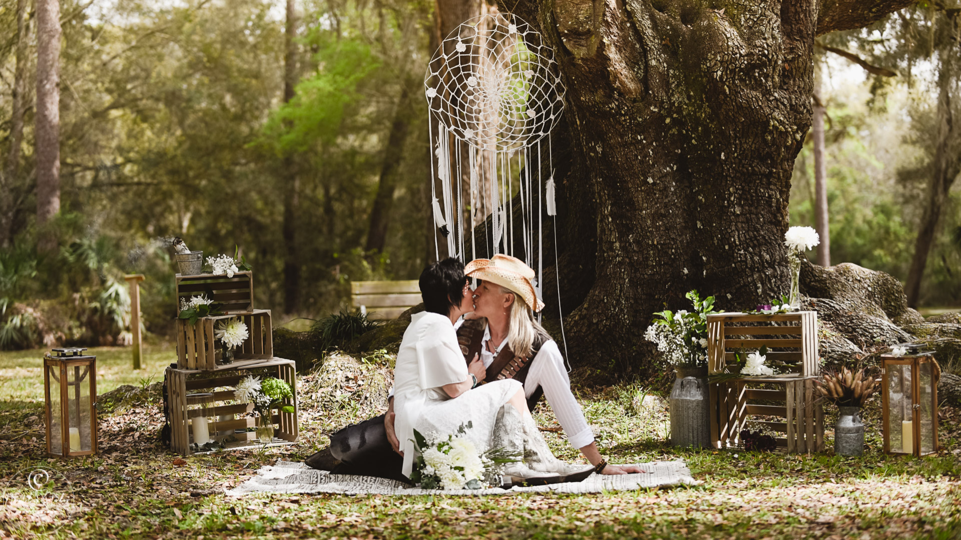 Native American inspired wedding elopement couple sitting under tree kissing