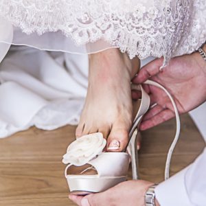 Photo showing brides pedicure putting on shoes