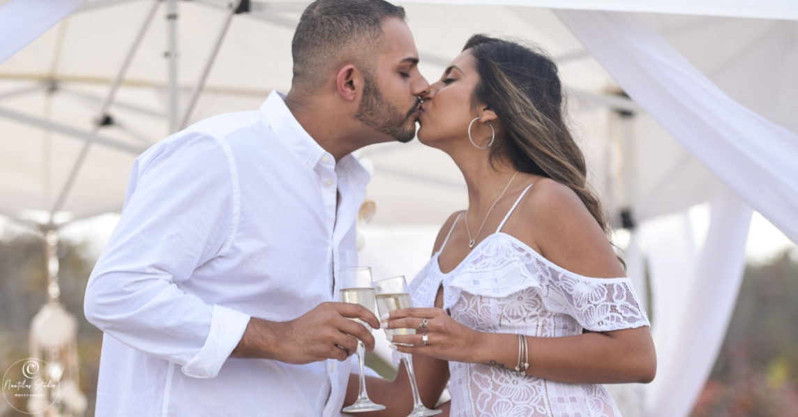 Couple kissing on the beach toasting