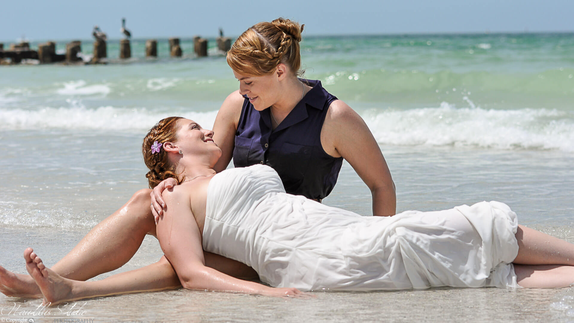 Same sex wedding in Florida photo showing two brides in the water trashing their dress