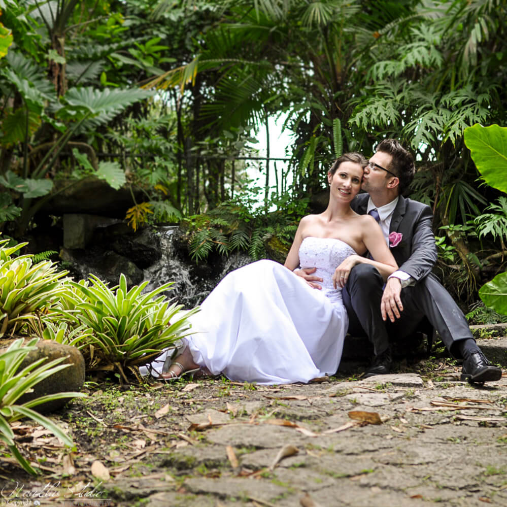 Photo of couple sitting at pond at their Flamingo Gardens wedding