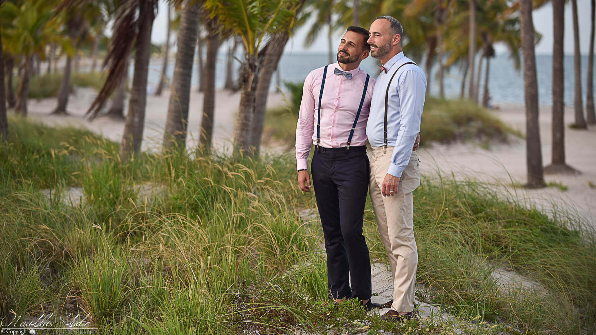 Gay wedding photo Florida showing two grooms under Palm trees on their wedding day