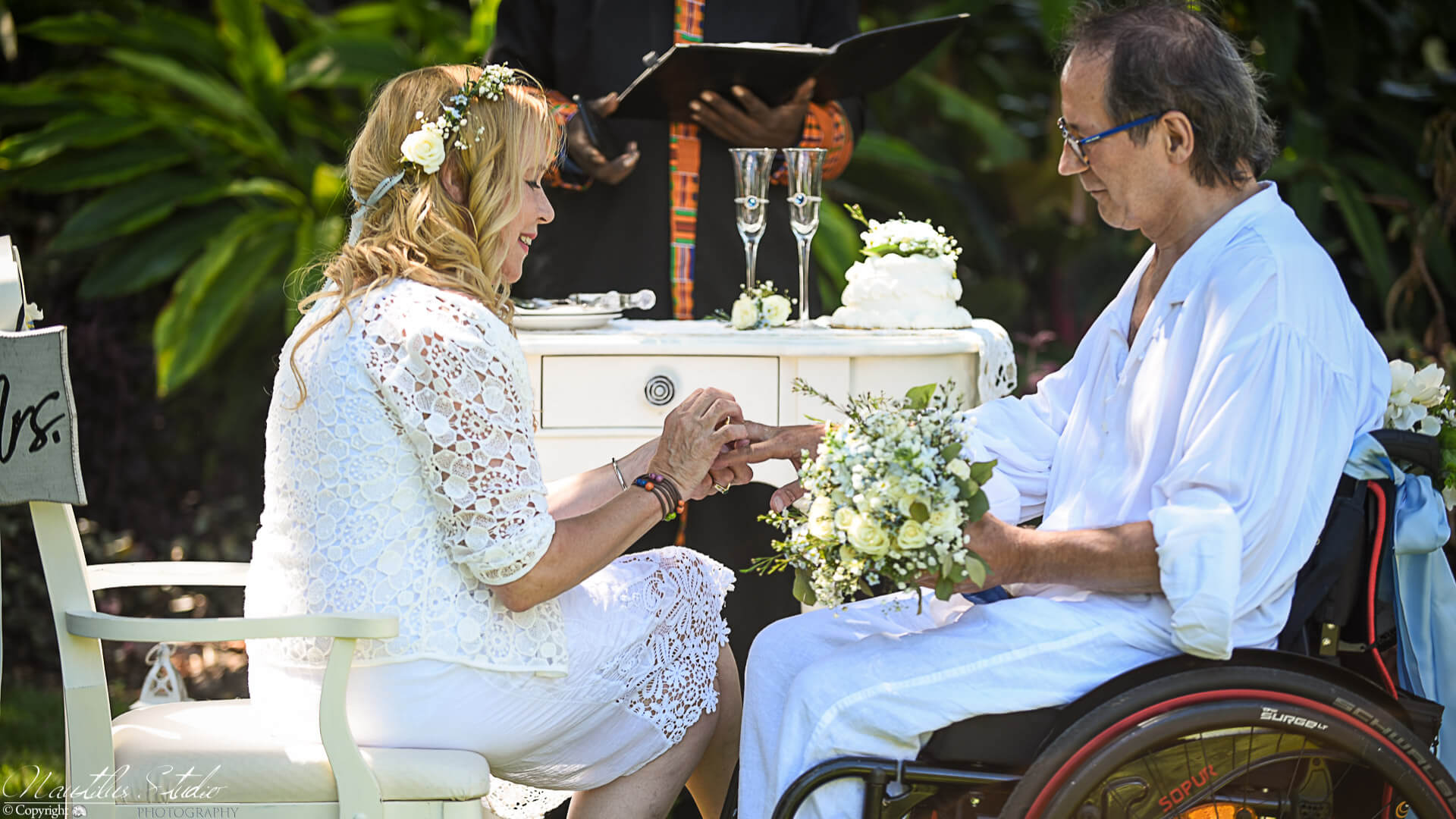 Wheelchair wedding in Florida, showing couple exchanging rings