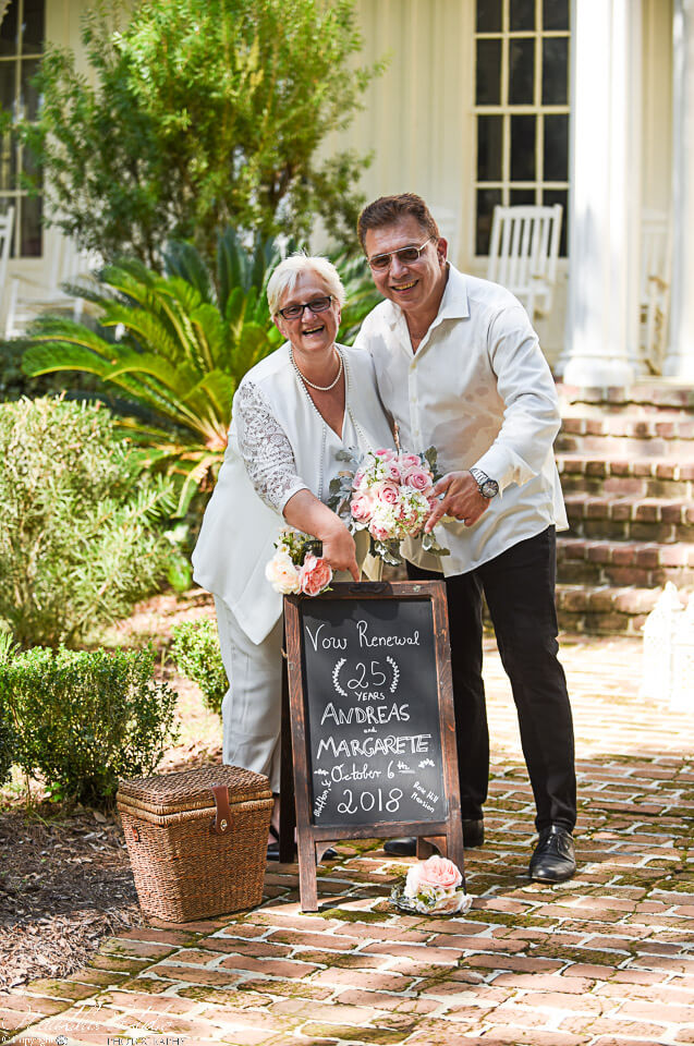 Vow renewal Florida photo of couple with their chalkboard sign celebrating their 25th Anniversary