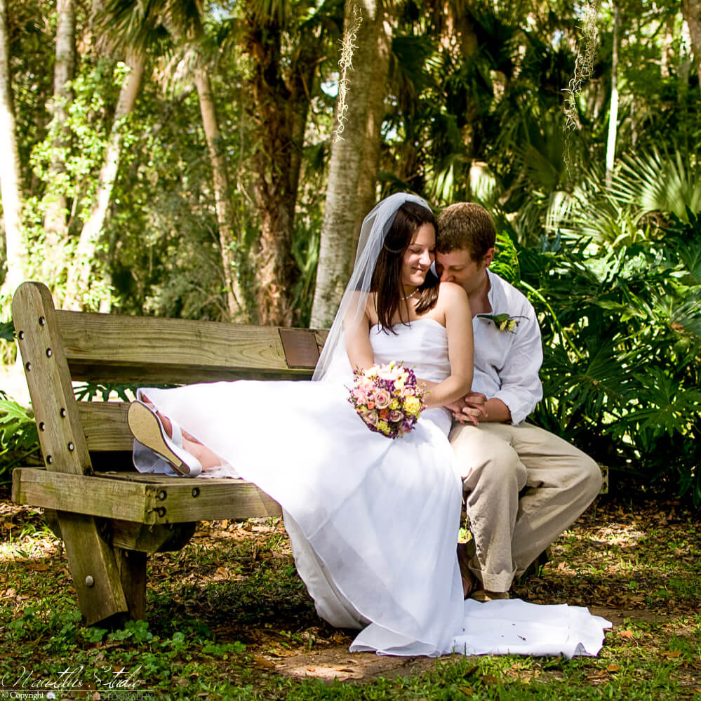 Washington Oaks Garden wedding photo of couple sitting on bench