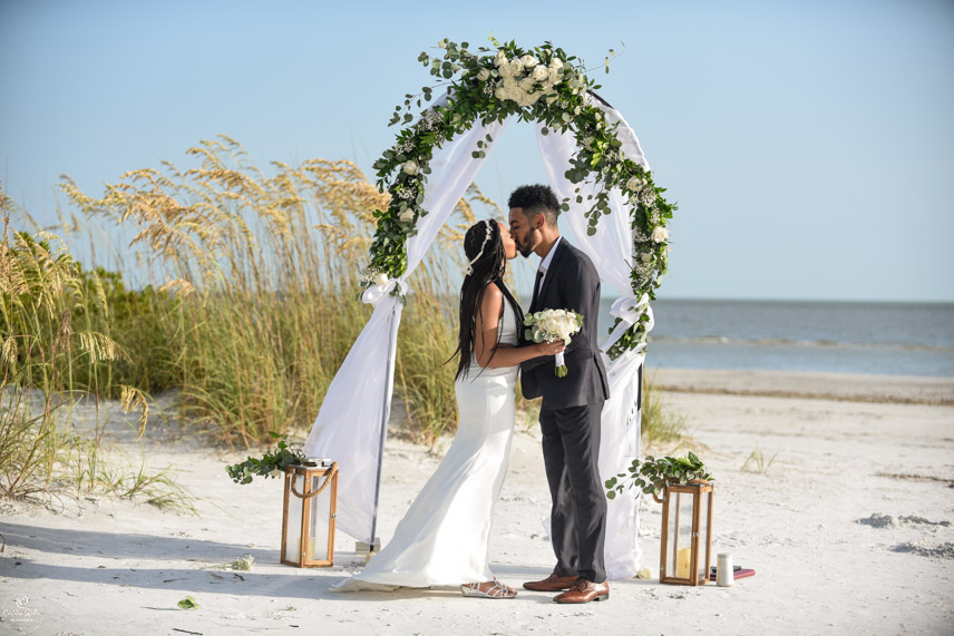 Photo of bride and groom under wedding arch fort Myers Beach Florida