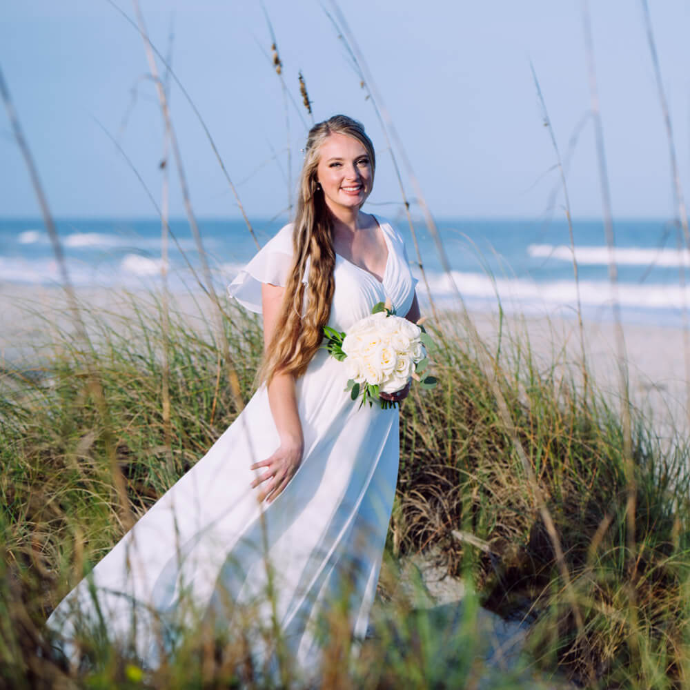 Beach wedding package in Florida, photo showing bride in sea oats at Cocoa Beach