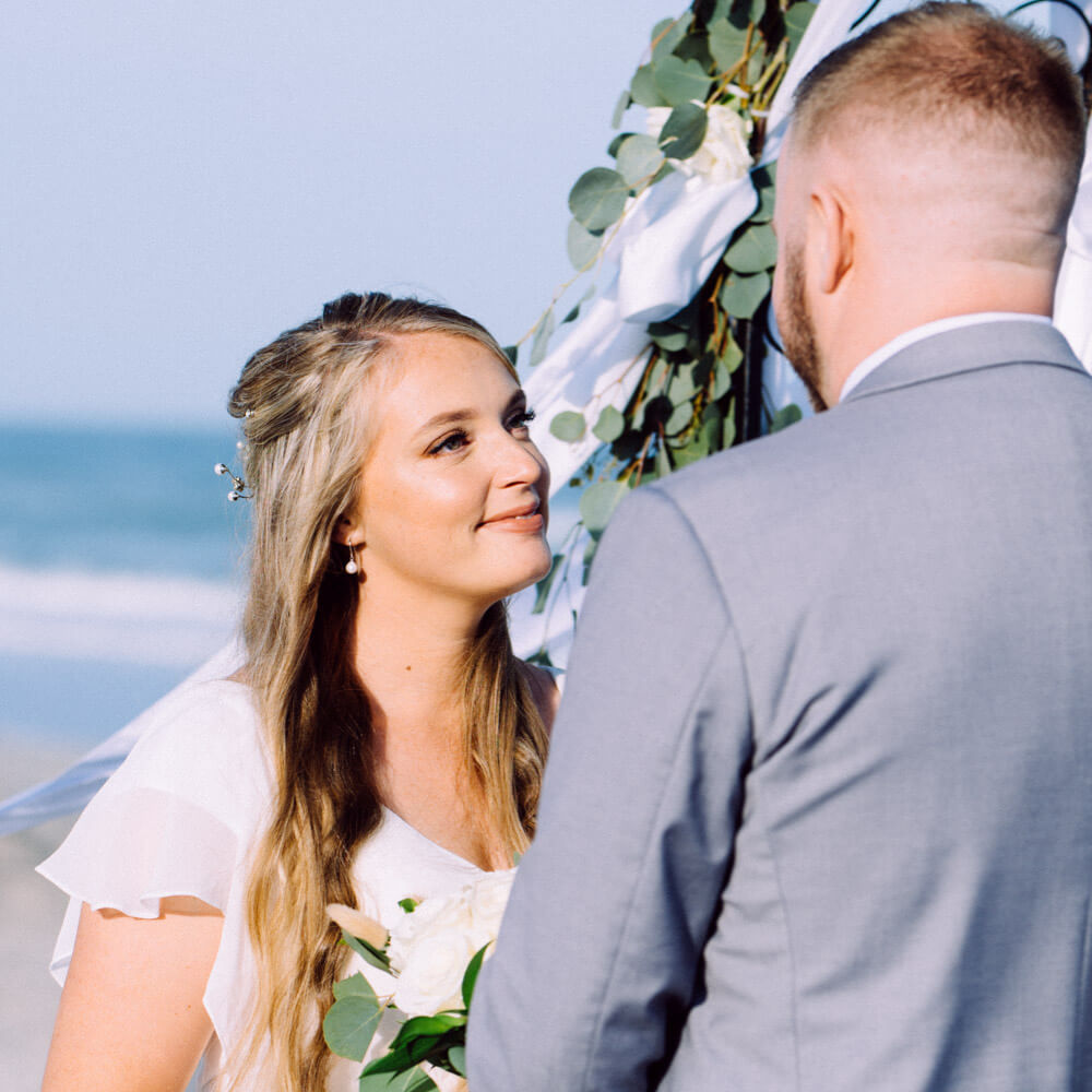 Wedding package for two, photo of bride looking at groom at their wedding in Cocoa Beach