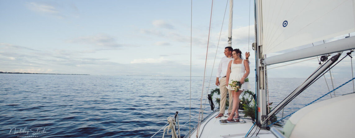 Photo of exclusive Sailboat Elopement in St. Petersburg. Photo showing the couple standing on deck