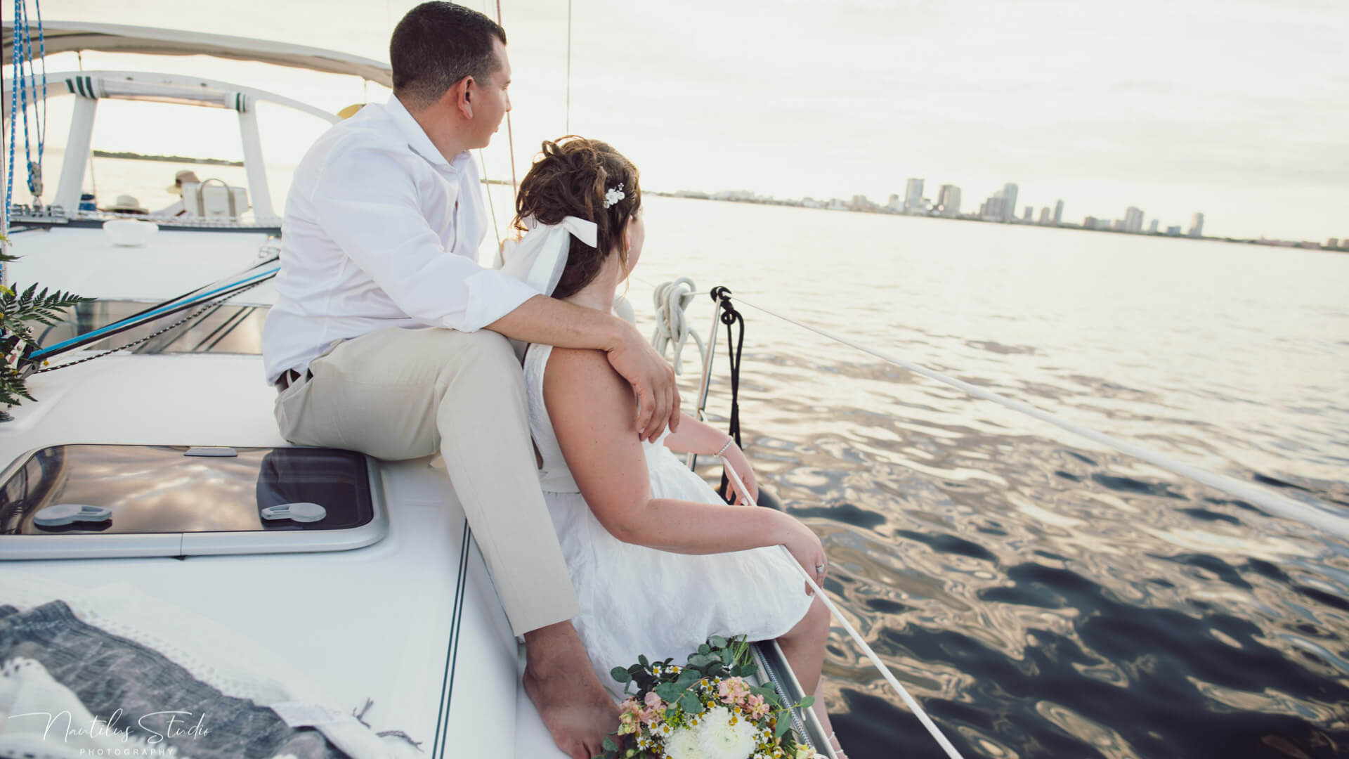 Photo of exclusive sailboat elopement in Tampa Bay, showing the couple watching the sunset