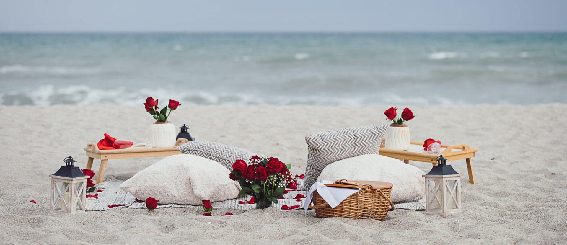 Photo of set up of a marriage proposal picnic with cushions and red roses in Clearwater Beach