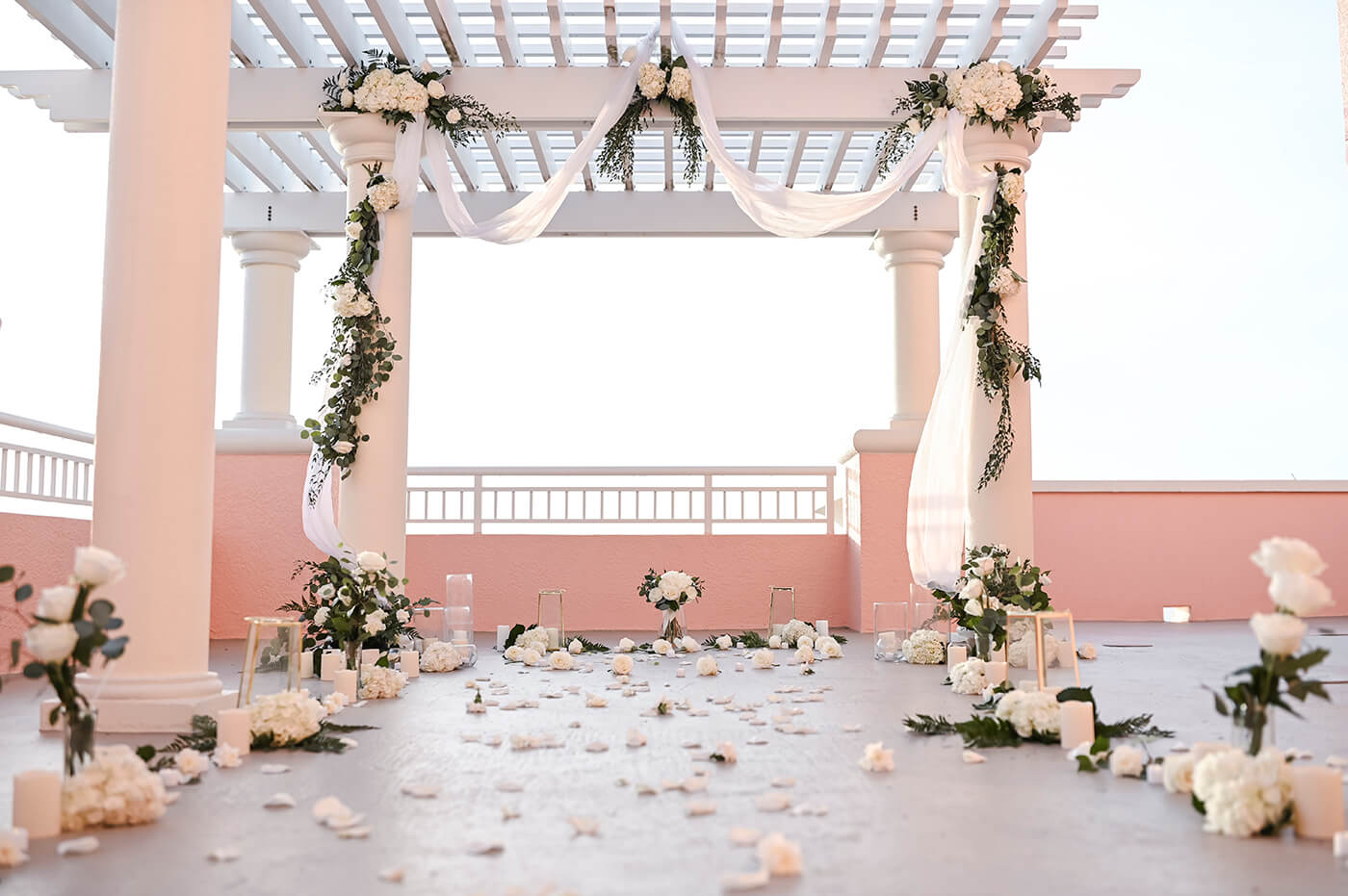 Custom marriage proposal planning in Florida photo showing rooftop proposal decoration with candles, decorated gazebo and aisle with fresh flowers.